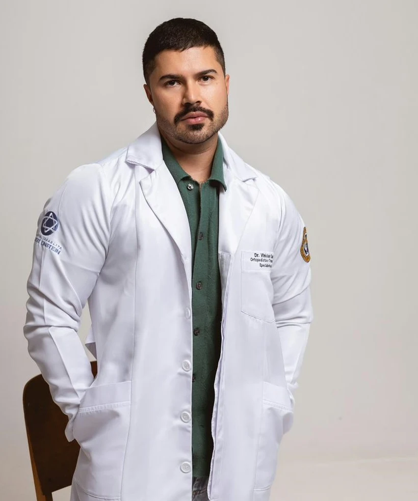 Dr. Vinícius Sanchez com jaleco médico — ortopedista e especialista em dor em São Paulo